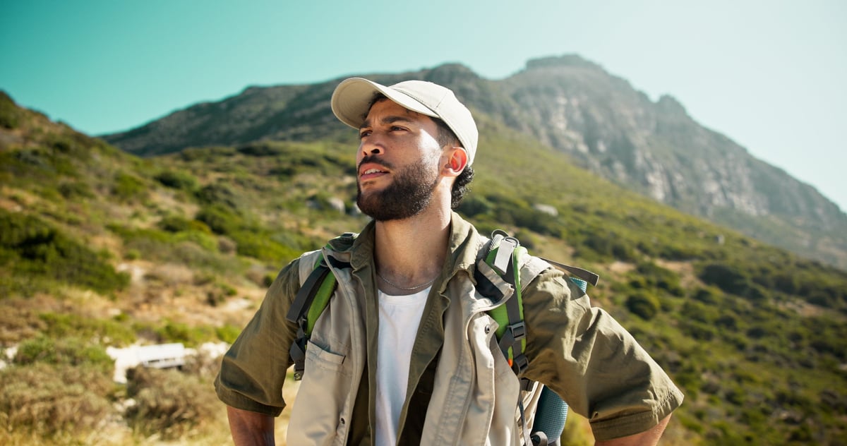 Caminante contemplando el paisaje montañoso durante una caminata de aventura