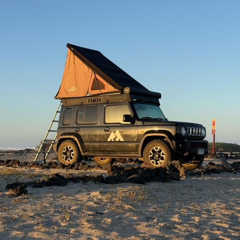 Golden SUV with orange roof tent on sandy beach at sunset, equipped for adventure camping