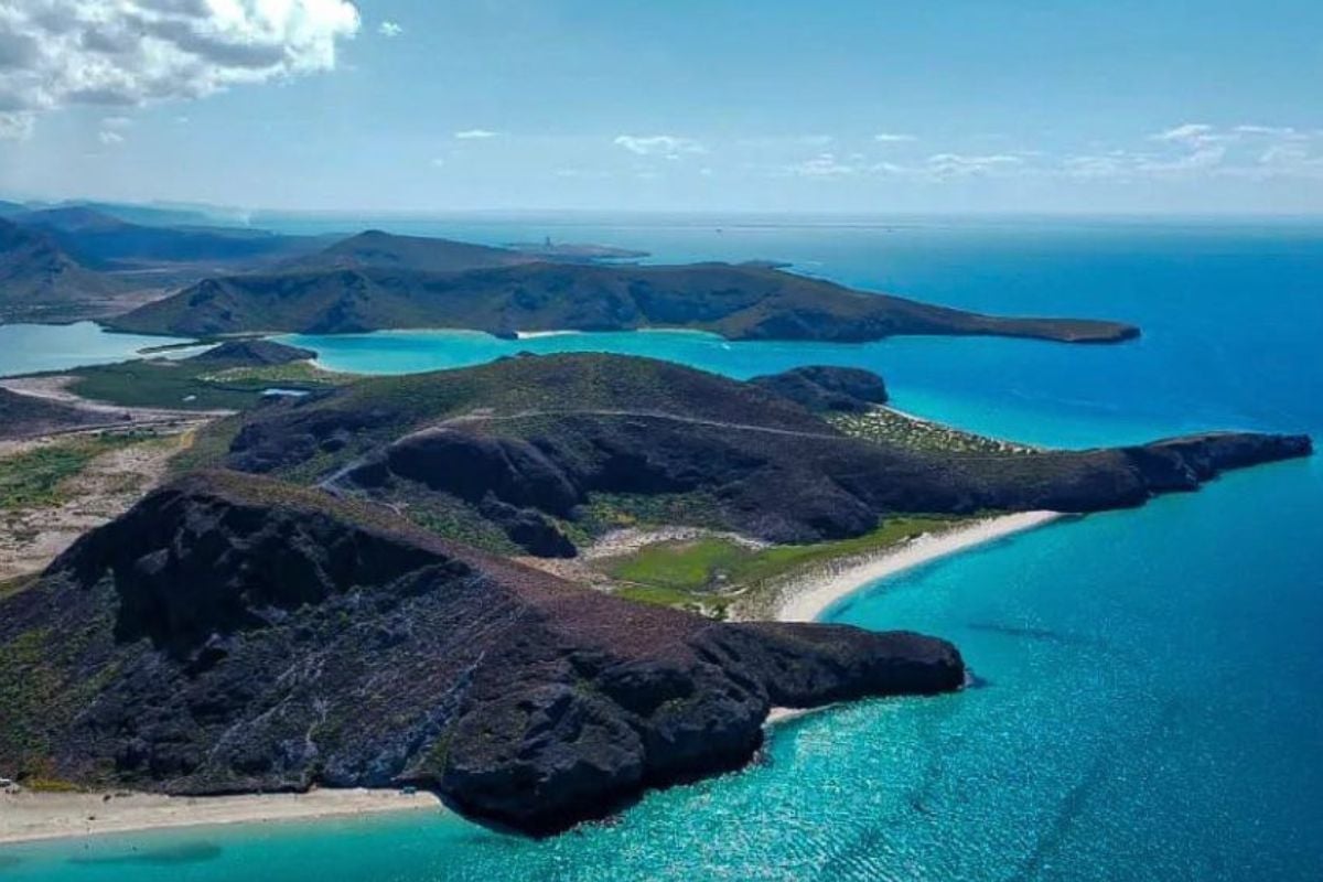 Aerial view of volcanic islands with turquoise lagoons and dark lava rock formations surrounded by blue ocean