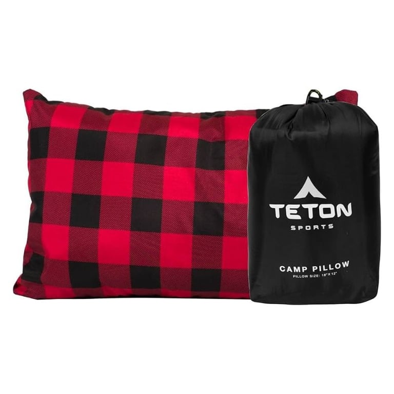 Red and black buffalo check camp pillow next to black Teton Sports storage bag