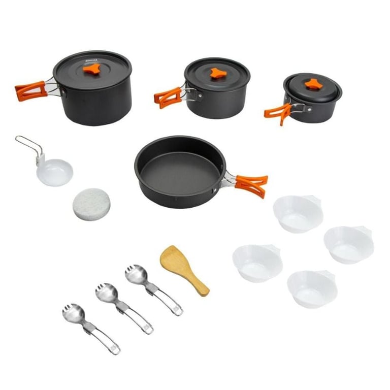 Camping cookware set with black nonstick pots, frying pan, bowls, utensils, and orange handles displayed on white background