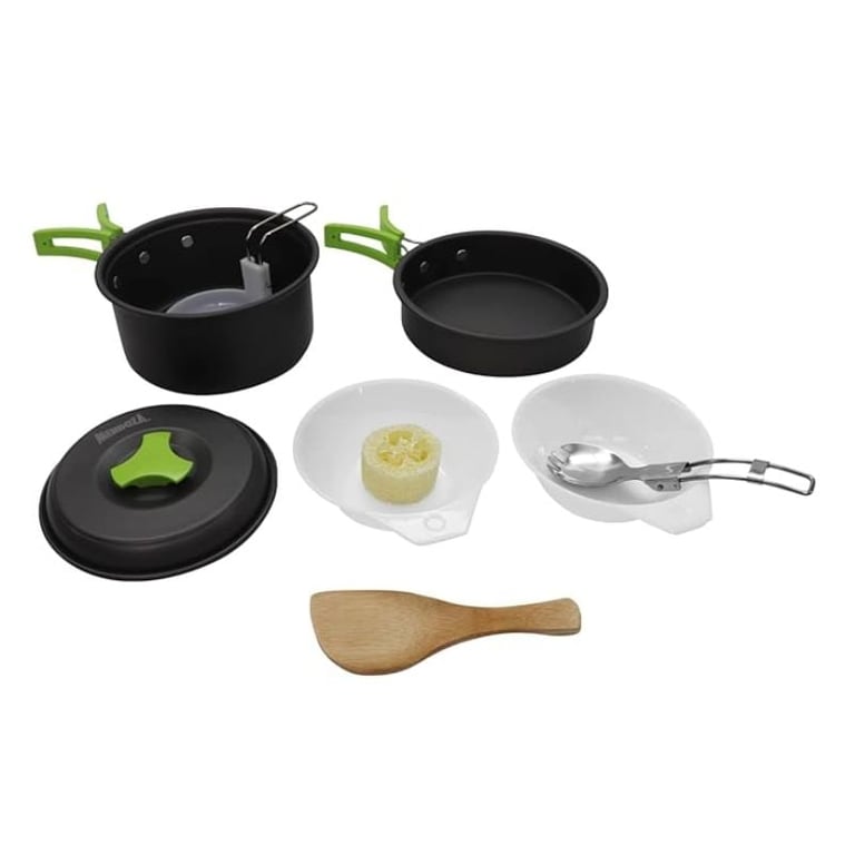 Black cookware set with green handles including pots, pans, lids, white dishes, metal strainer and wooden spoon