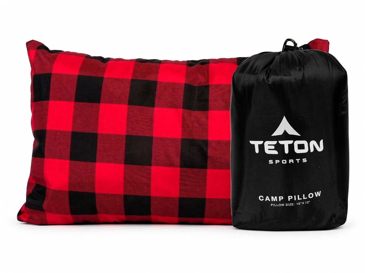 Red and black plaid camp pillow next to its black Teton Sports carry bag